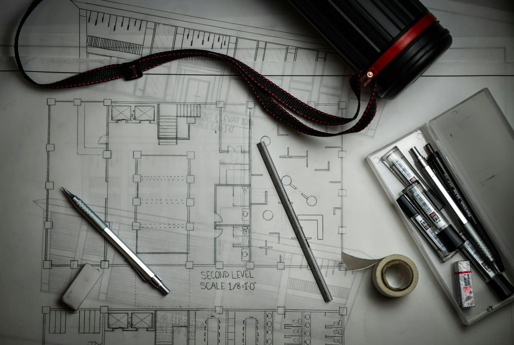 Construction plans with drafting tools on a desk